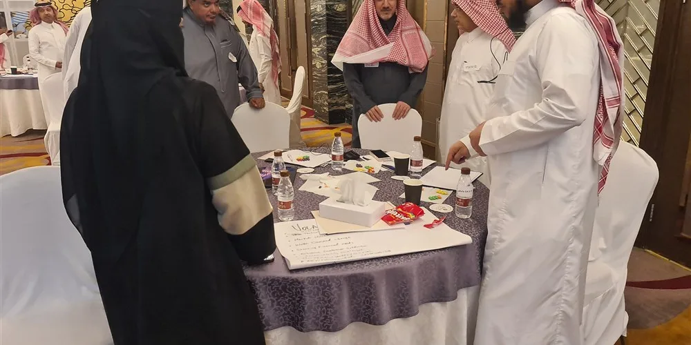 Leaders working together at a table during a change program in Riyadh